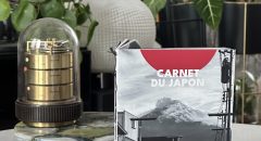 Livre photo Carnet du Japon, zine artisanal relié à la main, posé sur une table avec des plantes en arrière-plan