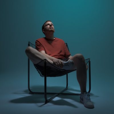 Alex assis sur un fauteuil moderne